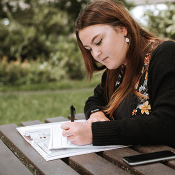 Woman writing outdoors