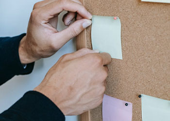 A person filling his board with sticky notes