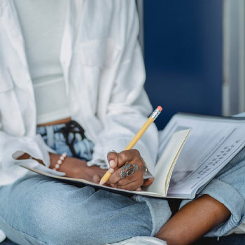 A woman studying for MCAT while seated on the floor