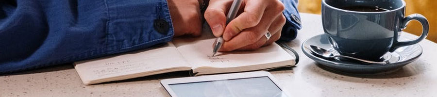 A man writing inside a coffee shop