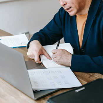 A male teacher evaluating GRE exam on his laptop