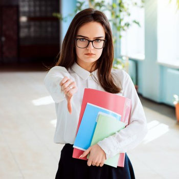 Sad female student with her thumbs down as she is not satisfied with her GRE score