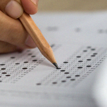 A hand holding a pencil and shading the SAT answer sheet