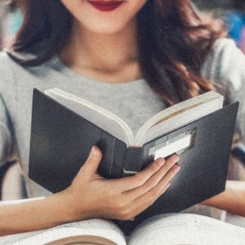 Woman reading a book, preparing for LSAT reading comprehension