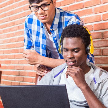 Two students looking at a laptop