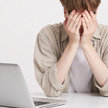 A stressful student covering his face