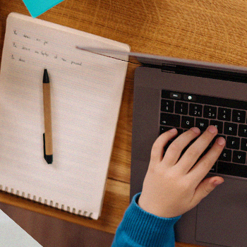 A student typing on his laptop