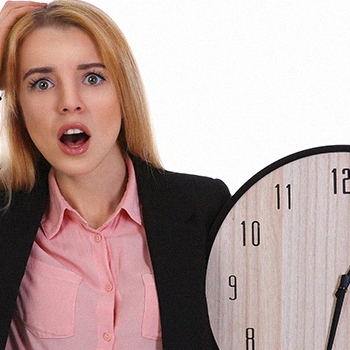 A woman in a suit holding a big clock