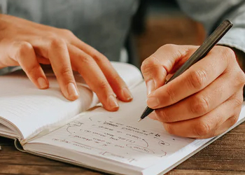 Person writing on a notebook