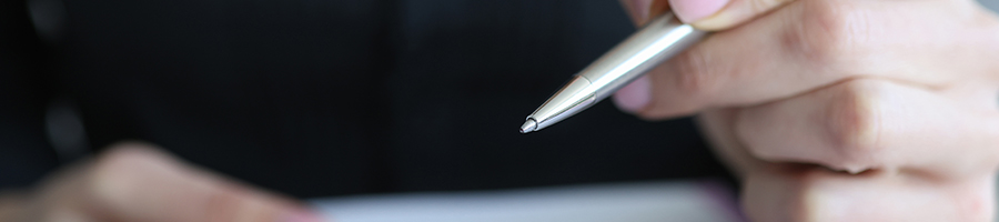 A person holding a pen close up image