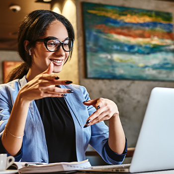 A woman talking in front of her laptop