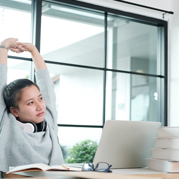 A girl stretching on her study station