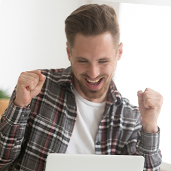 A cheerful guy in front of his laptop