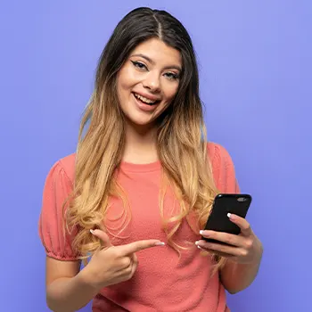 A woman smiling while showing her smart phone