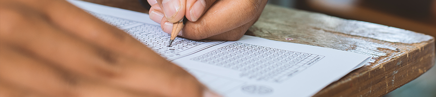 A person answering an examination on a wooden armchair