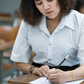 A young student in uniform answering an examination