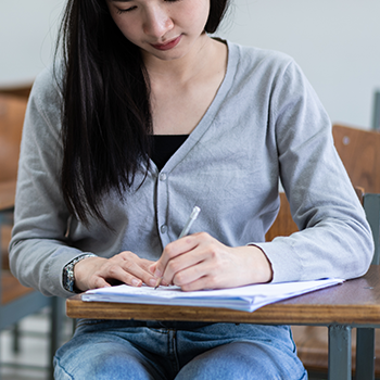 Young student answering an exam sheet