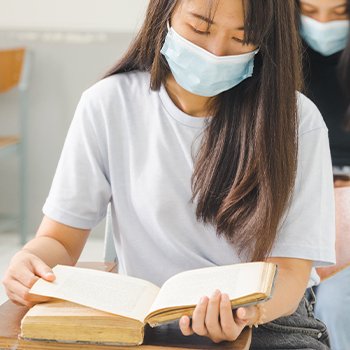 A young student reading a book