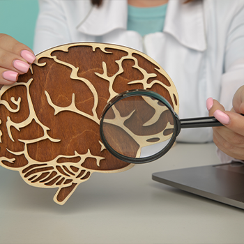 magnifying glass and wood sculpted brain