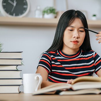 woman studying stack of books