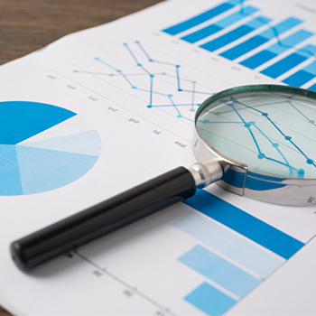 paper with graphs and a magnifying glass on it