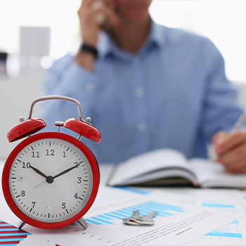 man with a red clock beside him