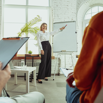 female professor pointing at the whiteboard