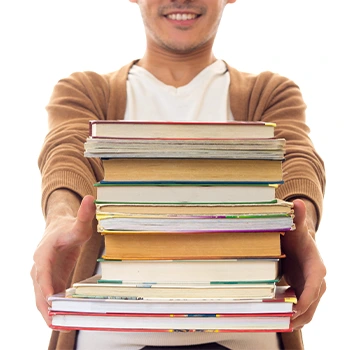 male holding stack of books
